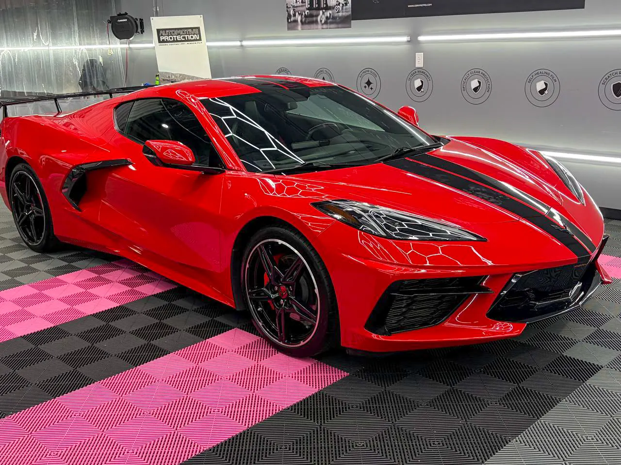 Front three-quarter view of Stella, a Torch Red C8 Corvette with black racing stripes